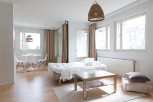 a living room with a couch and a table at Stylish 66m2 apartment with private sauna and balcony in Helsinki