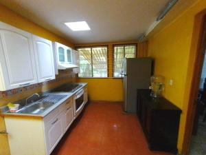 une cuisine avec un évier et un réfrigérateur dans l'établissement El Refugio, à Oaxaca