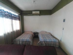 - 2 lits dans une chambre avec un canapé dans l'établissement El Refugio, à Oaxaca