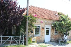 a small stone house with a white door at Pereira Cabana in Porto de Mós