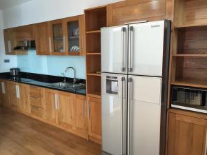 a kitchen with a refrigerator and wooden cabinets at Hana Homestay in Hai Phong
