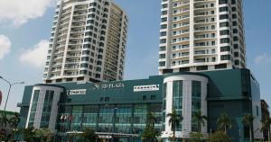 two tall buildings in a city with palm trees at Hana Homestay in Hai Phong