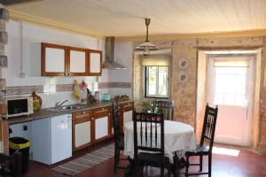 a kitchen with a table and chairs in a room at Pereira Cabana in Porto de Mós