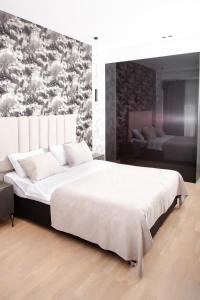 a bedroom with a large white bed with a painting on the wall at Guesthouse - 3 room in Sumqayıt