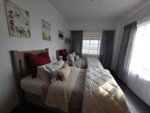 una camera con due letti con cuscini sopra di Graskop Cottage a Graskop Altre 9 foto
