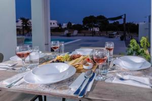 a table with plates of food and glasses of wine at Vigla Kiotari in Kiotari