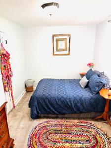 a bedroom with a blue bed and a rug at Cici's Guest House in Laurel