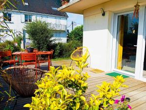 a wooden deck with a table and chairs on it at Superbe T3 terrasse et jardin centre bourg in Caudan