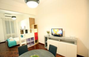 a living room with a table and a television in it at Armuzzi Garden, Roma e mare in Lido di Ostia