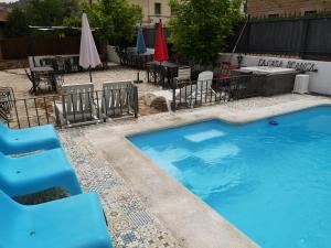 a swimming pool with chairs and tables and umbrellas at Casas del Alto Tajo - La Casa Blanca in Ablanque