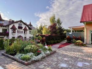 a garden in front of a house with flowers at Kalna iela 21 apartment in Sigulda