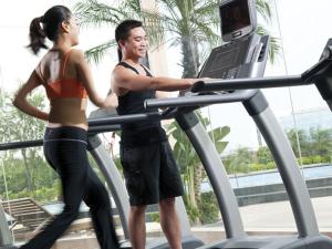 a man and a woman running on a treadmill at HJ International Hotel - Free shuttle bus to Canton Fair during exhibition period in Dongguan