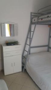 a bunk bed with a ladder next to a desk at Any Summer garden house in Skála Nikíta