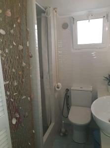 a bathroom with a toilet and a sink and a window at Any Summer garden house in Skála Nikíta +7 photos