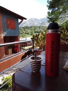 a red thermos sitting on a table with a cup at A Mi Manera Apart in Merlo +41 photos