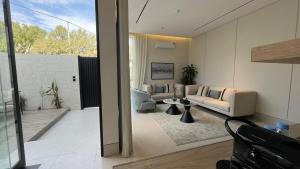 a living room with a couch and a table at شاليهات قمر الشفا لبيوت العطلات التصنيف اقتصادي in Ash Shafa