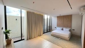 a bedroom with a bed and large windows at شاليهات قمر الشفا لبيوت العطلات التصنيف اقتصادي in Ash Shafa +42 photos