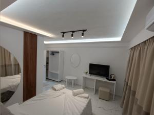 a white room with two beds and a television at Hotel Elisabet in Sarandë