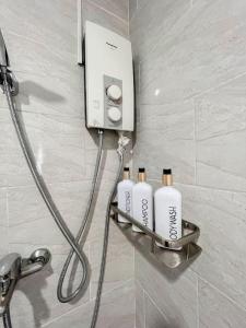 three shampoo bottles on a shelf in a bathroom at 1BR By The Airport at Amani Grand Residences in Lapu Lapu City
