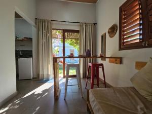 a kitchen with a table and two stools in a room at Zero Meia Um Pousada in São Miguel do Gostoso