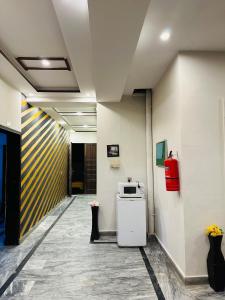 a hallway of an office with a microwave on the wall at The Luxury Girls Hostel- LDA Avenue in Lahore