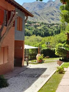 a brick house with a mountain in the background at A Mi Manera Apart in Merlo