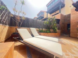 a pair of white chairs sitting on a balcony at Tinajas Penthouse Views in Corralejo
