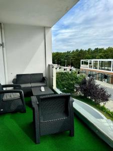 Un balcón con una mesa y sillas en un edificio. en Apartament przy plaży, en Władysławowo