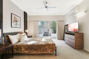 a bedroom with a large bed and a television at TWELVE at 12 Private Central Maroochydore in Maroochydore