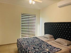 a bedroom with a bed and a window with a blanket at Casa del Lago in Veracruz +19 photos