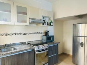 a kitchen with a stove and a stainless steel refrigerator at Casa del Lago in Veracruz