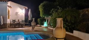 a swimming pool with two vases next to a house at Villa El Huerto in Orba +23 photos