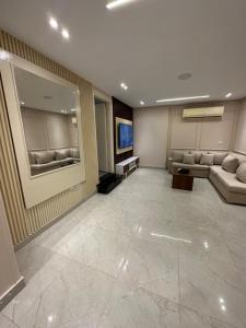 a lobby with a waiting room with couches and a television at شقه بالمهندسين أول سكن لأصحاب الذوق الرفيع in Cairo +4 photos