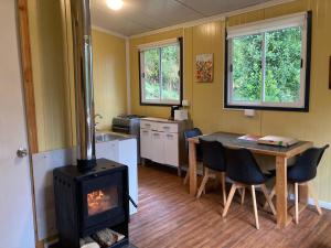 a kitchen with a stove and a table in a room at CABAÑAS RÜPÜ PUYUHUAPI in Puerto Puyuhuapi