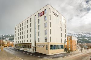 a large white building on the side of a street at Clarion Collection Hotel Helma in Mo i Rana