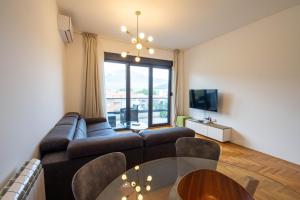 een woonkamer met een bank en een tafel bij Apartman 20 in Trebinje