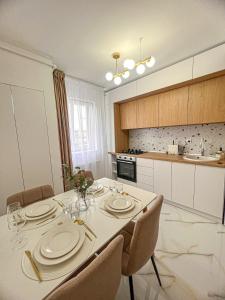 une salle à manger avec une table et des chaises et une cuisine dans l'établissement Mirajul Apartment, à Turda
