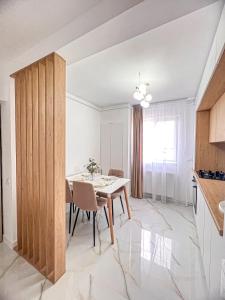 une cuisine et une salle à manger avec une table et des chaises dans l'établissement Mirajul Apartment, à Turda 17 autres photos