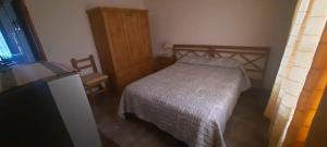 een kleine slaapkamer met een bed en een houten kast bij La Maru in Villa Giardino +25 foto's