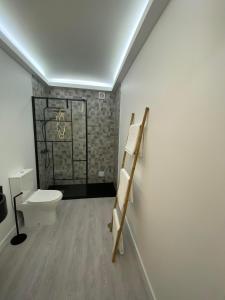Un baño con inodoro y pared. en AL 30 Reis, en Vila Franca do Campo