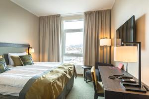 una camera d'albergo con un letto, una scrivania e una finestra di Home Hotel Helma a Mo i Rana Altre 26 foto