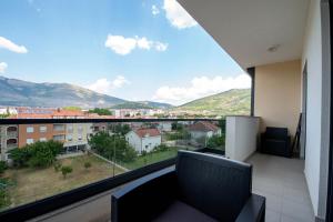 een balkon met uitzicht op de stad en de bergen bij Apartman 20 in Trebinje