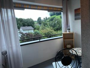 a balcony with a window with a chair and a view at Studio Wettingen möbliert, 25min bis Zürich in Wettingen