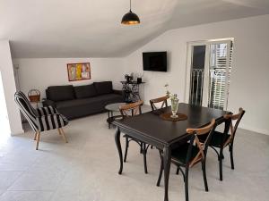 a living room with a black table and chairs at Quince Luxury Apartment in Đenovići