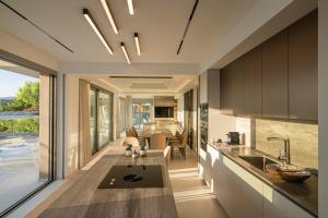 an open kitchen and dining room with a view of a living room at Beachfront Villa Edem Dedicated Beach Space - Heated Pool in Agios Nikolaos