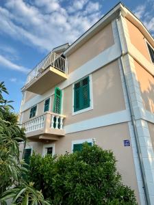 un edificio con persianas verdes y balcón en Quince Luxury Apartment, en Ðenovići