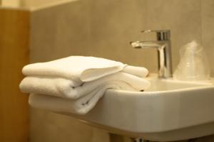 a pile of towels sitting on top of a sink at SeaSide Sopot - butikowe noclegi przy plaży in Sopot