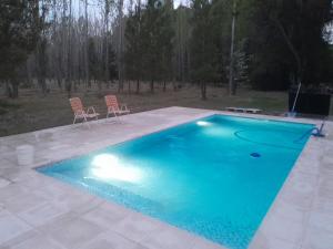 a large swimming pool with two chairs next to it at La Venecia Cabañas in San Rafael