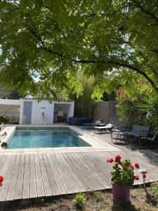 a backyard with a swimming pool and a wooden deck at Villa SChic in Marseille