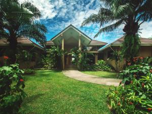 a house with a green lawn and palm trees at Villa Galanga 3 Bedrooms Plus Cottage Room in Ao Nang Beach